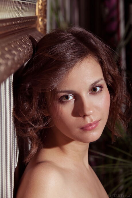 Lean teen Tirata removes a shawl to model in the nude on a sofa