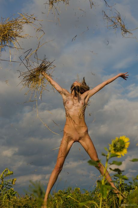 Petite Teen Iris D wird nackt in einem Feld aus Wildblumen nackt
