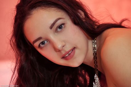 Winsome teen Solange with small tits and bald pussy posing naked on the bed