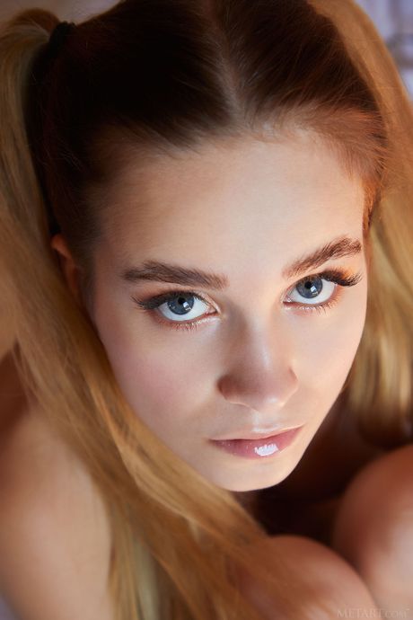 Charming teen Cassia removes her hair in pigtails while getting naked