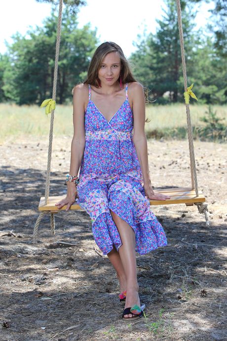 Cute teen Mirabella removes a long dress to pose nude on a swing