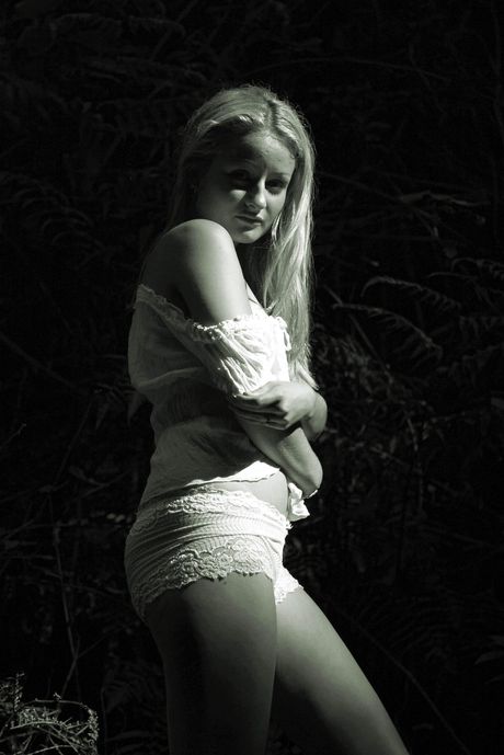 Sexy blonde Loni W strips naked and poses in the water during a solo shoot