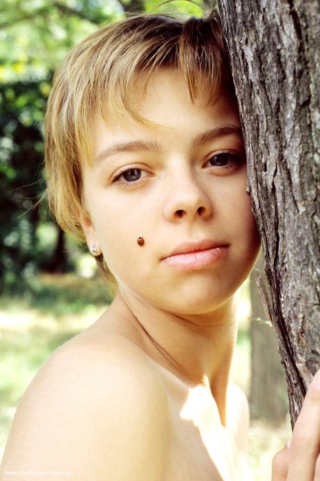 Russian venus Olga poses naked in the forest to show her tiny tits and ass