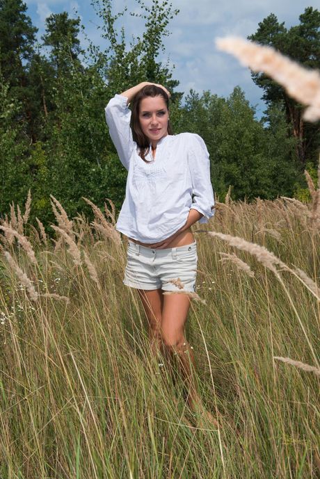 Lovely teen Semmi A gets naked in a field of flowers and poses for a glamour shoot