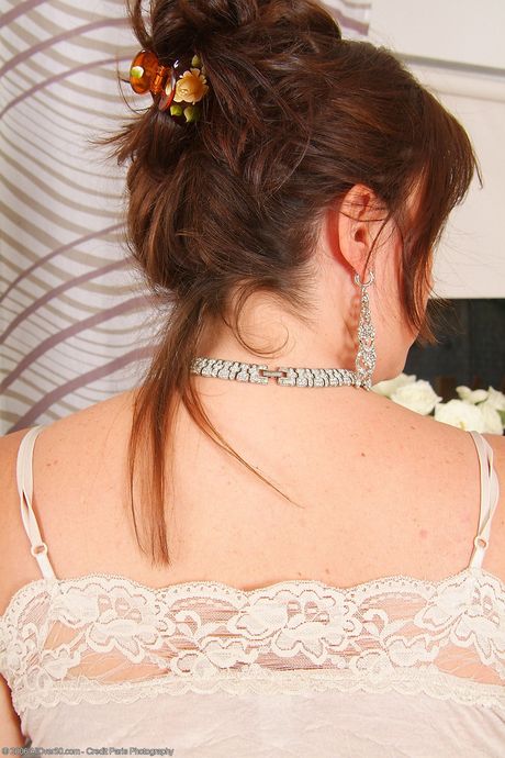 Mature redhead Marishka unveils her big tits and poses in a solo