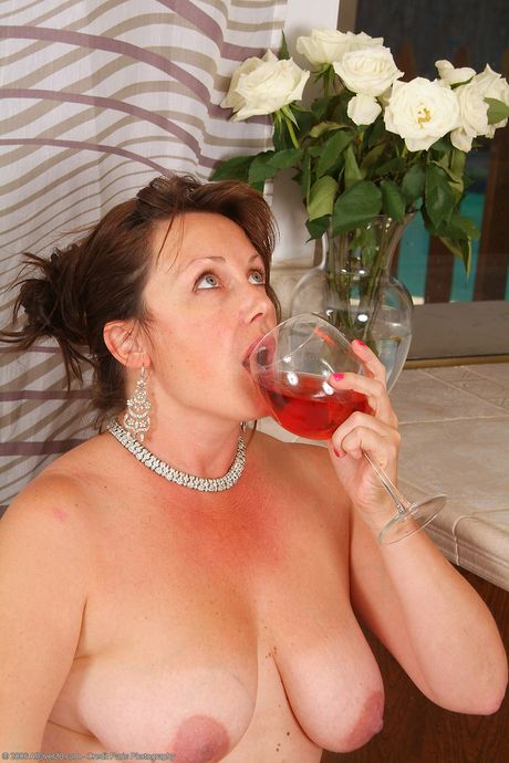 Mature redhead Marishka unveils her big tits and poses in a solo