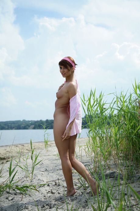 Lean teen Katrin B demonstrates her big tits and poses naked on the beach