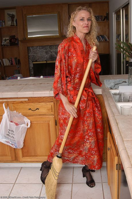 Blonde mature Kira shows her big booty and spreads her pussy in the kitchen