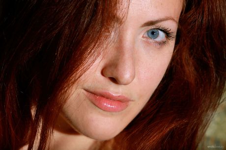 Young redhead Callista Simon takes off everything in a field of flowers
